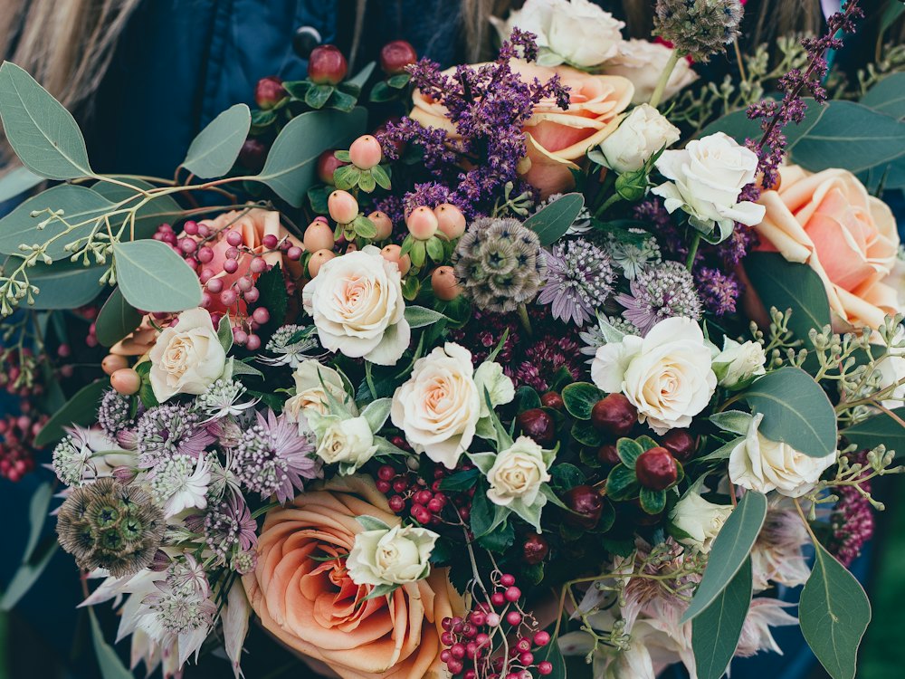 Composition florale généreuse de roses et de fleurs de saison