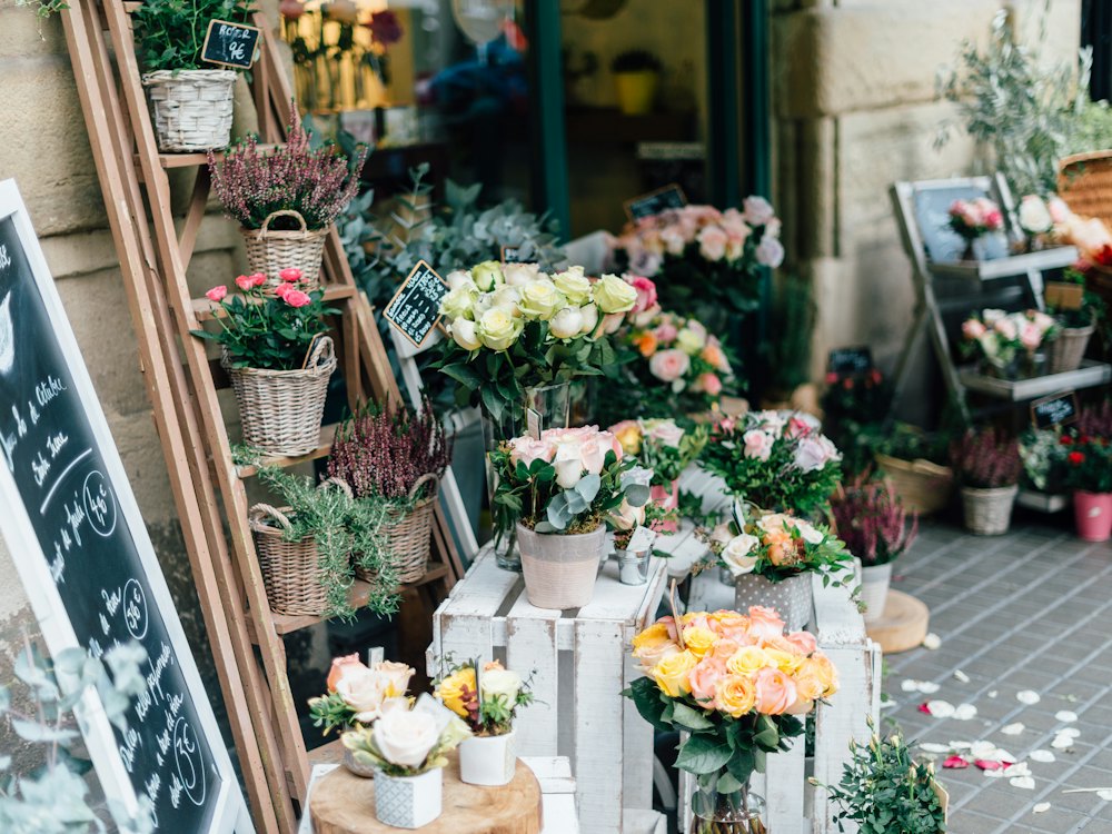Devanture d'un fleuriste avec seaux de fleurs et plantes