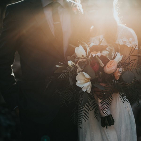 Mariée tenant un bouquet de fleurs blanches et roses