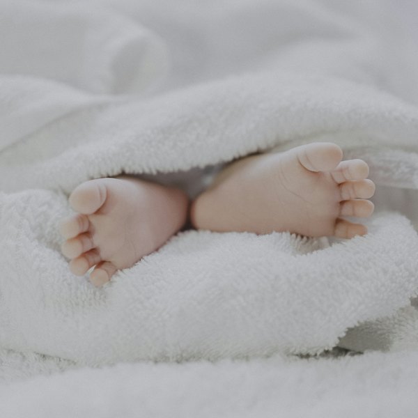 Pieds d'un nouveau-né dans une couverture blanche